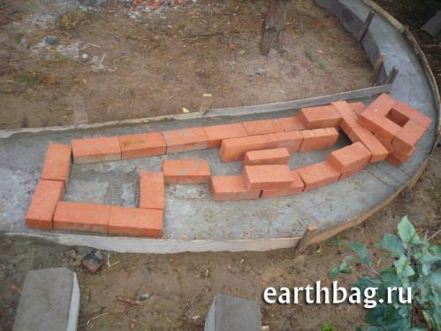 Mass heater fireplace built directly into the earthbag wall