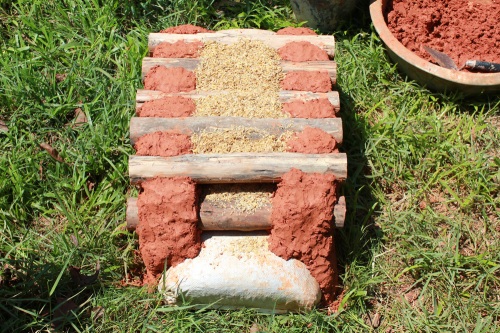 Demonstration wall showing cordwood stacked on earthbag bag foundation (click to enlarge)